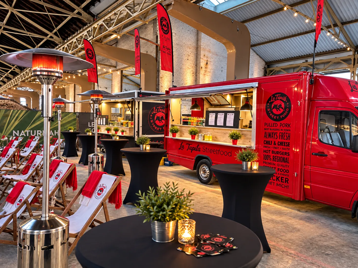 Roter La Tapita Foodtruck in einer Eventhalle mit Stehtischen und Heizpilz